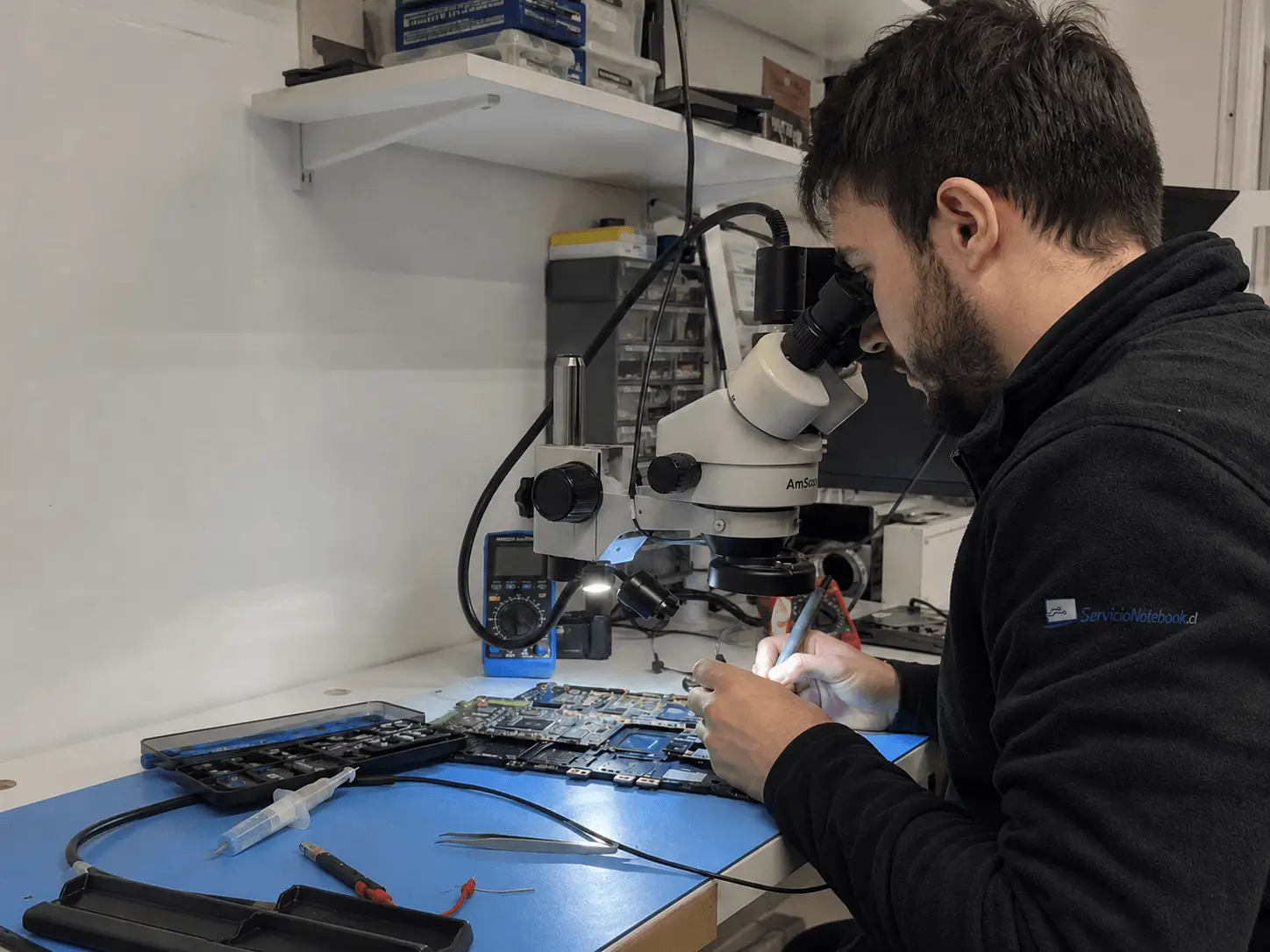 Técnico realizando mediciones electrónicas en un notebook en el taller